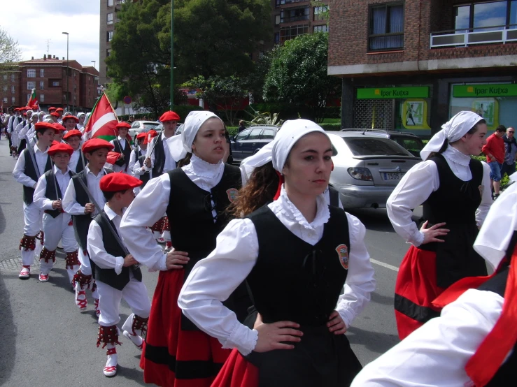 a group of women standing in line near each other on the street