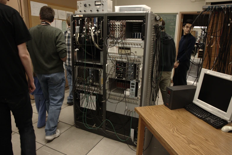 people are standing around an electrical cabinet