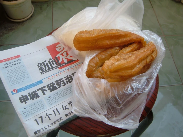 two donuts in plastic wrappers on top of a table