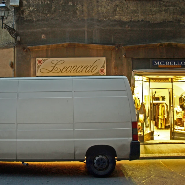 a van parked outside a clothing store next to the street