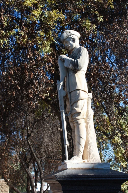 a statue of a soldier with a flag and flag pole