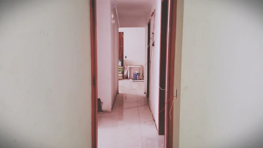 a narrow room with white walls and pink floor