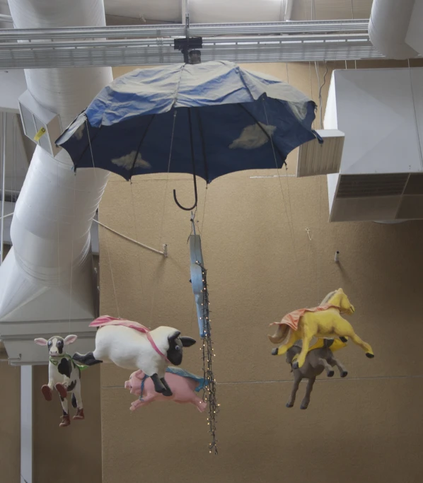 two figurines are suspended in the air by a wire