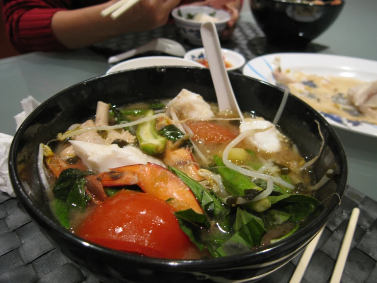 a pot filled with food and chop sticks