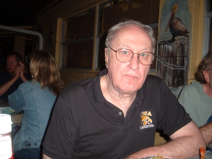 a man sitting at a table in a bar and looking out the window