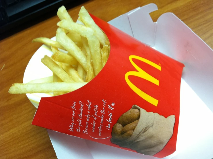 a plate with some french fries and a box on a table