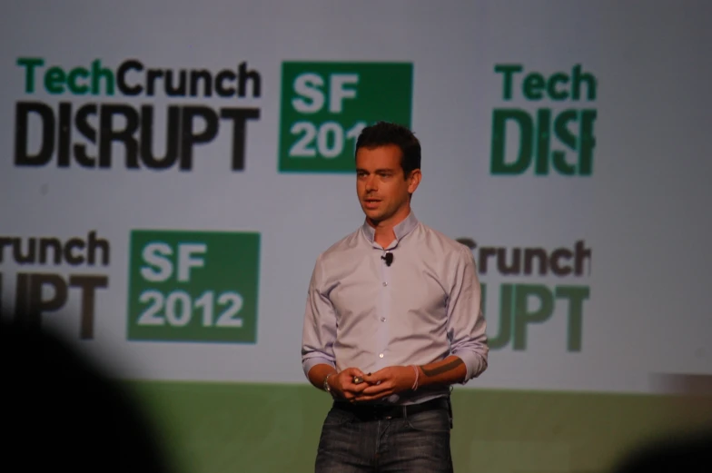 a man stands while speaking at a techcrunch disrupt event