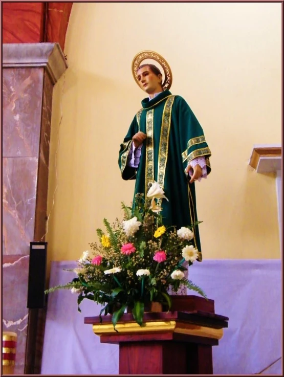 the statue is standing at the altar with flowers on it