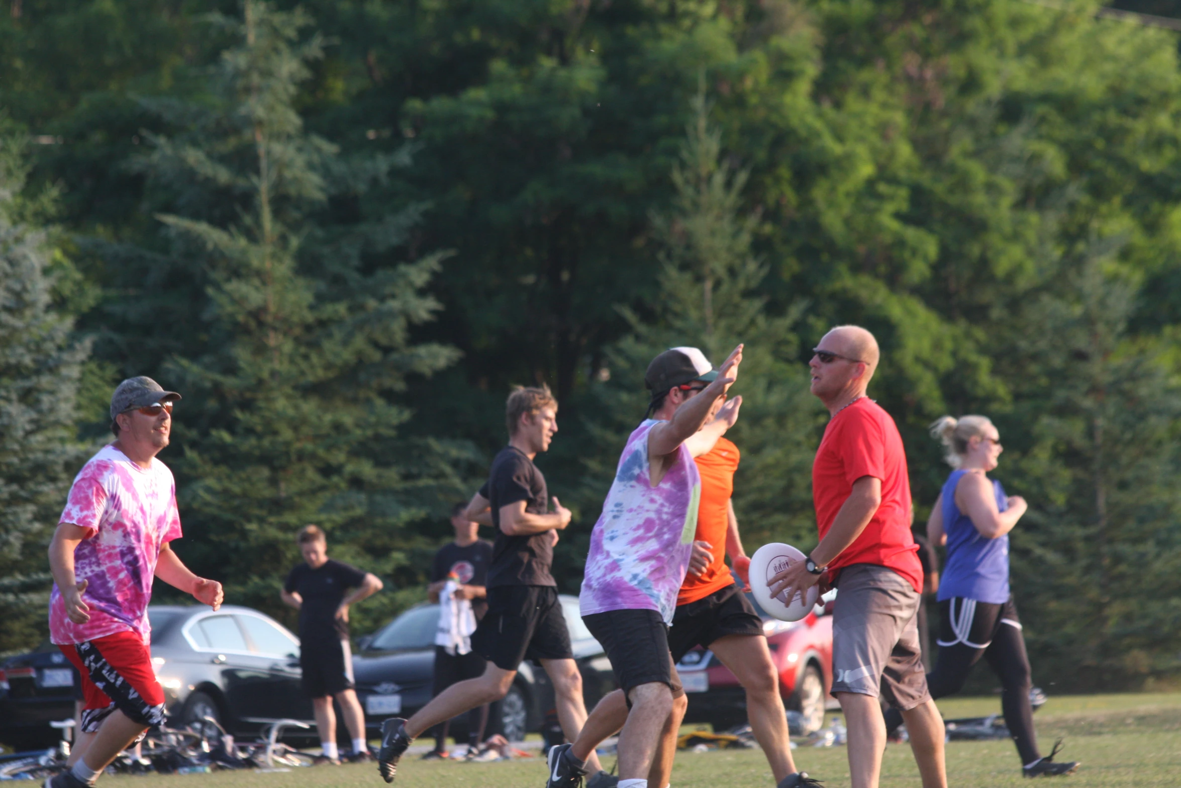 a group of people holding frisbees on top of a field