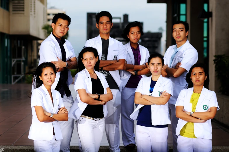 several people are dressed in white clothes and smiling for a po