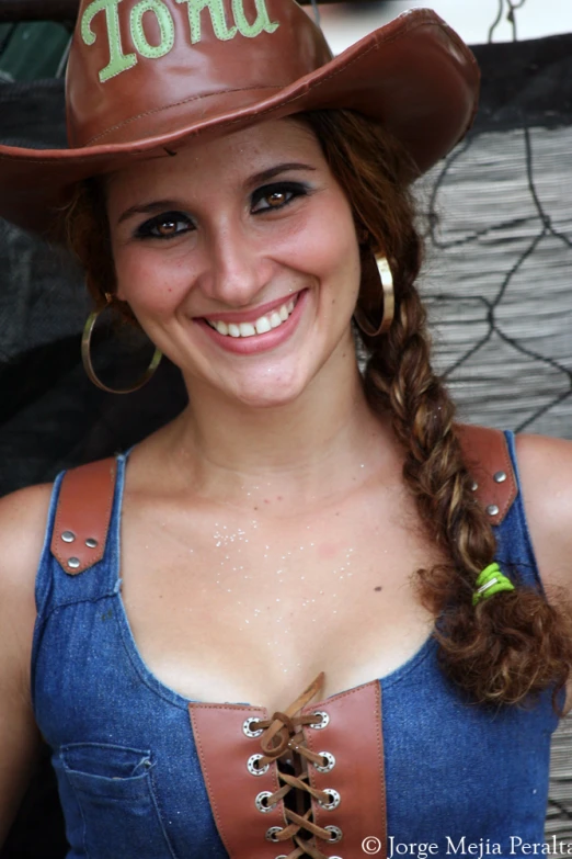 a woman wearing a leather cowboy hat and smiling