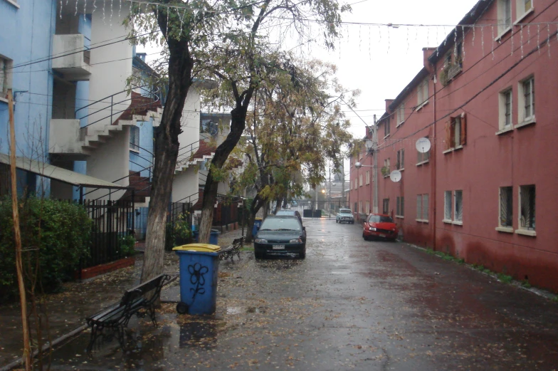 there is a bench on a rain soaked city street