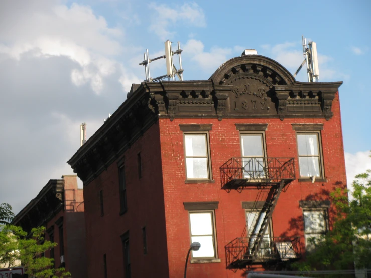 red brick building with a sky background with clouds