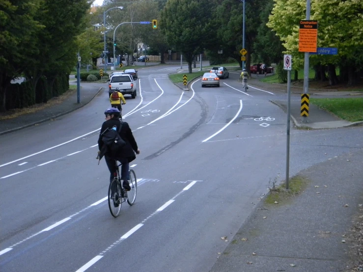 two bicyclists riding their bikes through a crosswalk