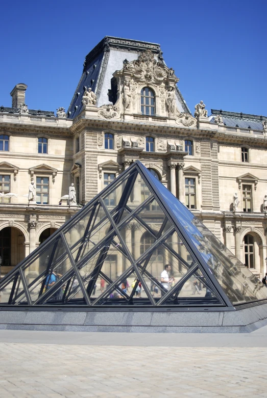 a large building with a glass pyramid in front of it