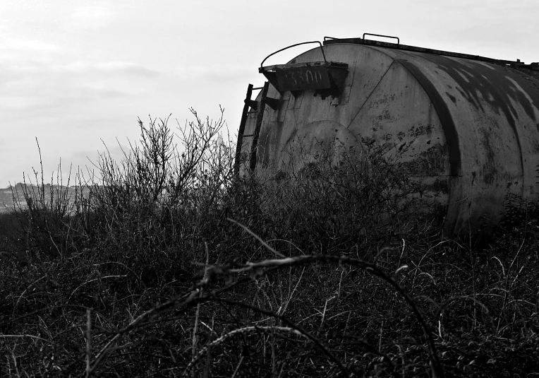 an old tanker is sitting in the grass