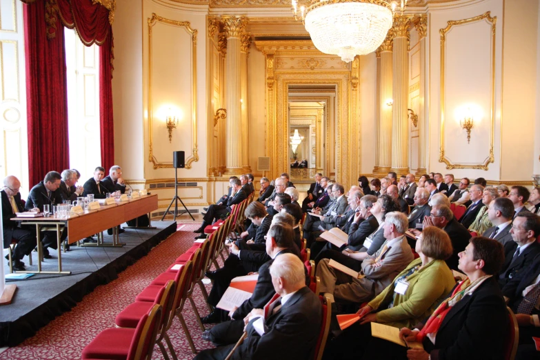 a large crowd of people sitting at tables in chairs