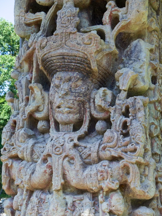 a close up of a stone statue near some trees