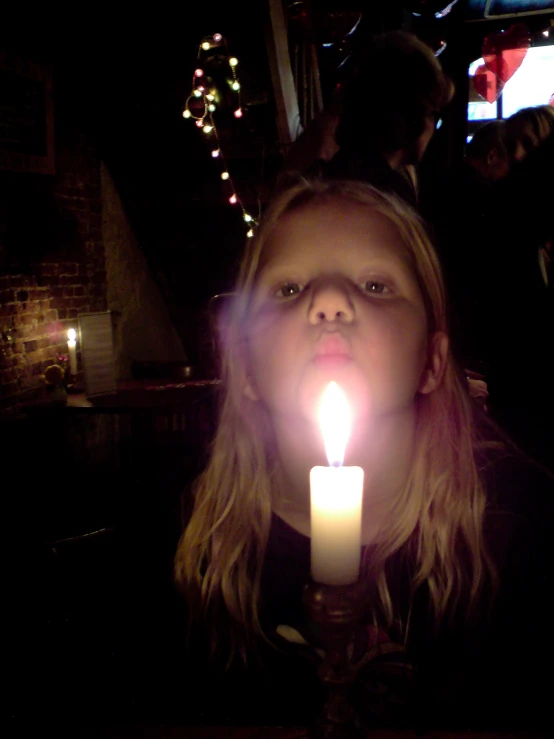 a girl with a candle in front of her