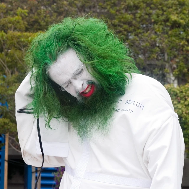 a person with green hair and white make up on their face