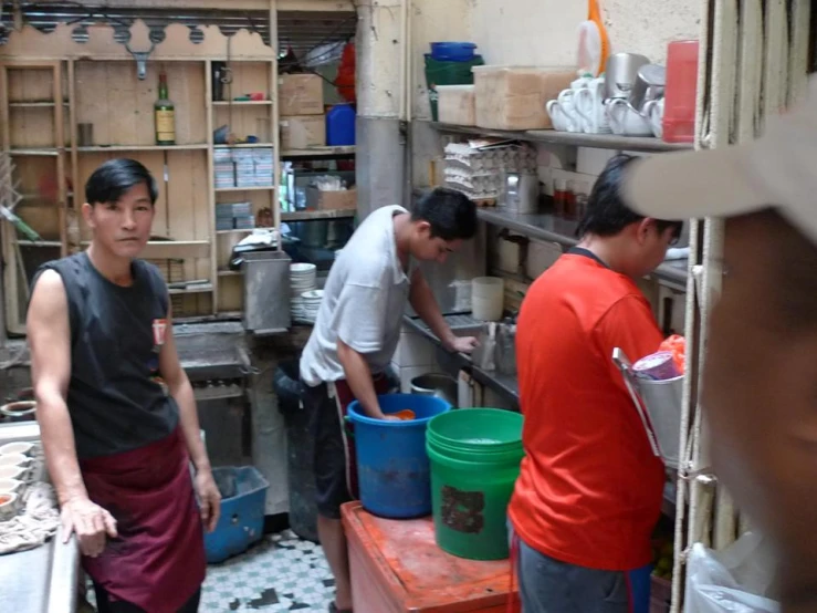 some people in an asian kitchen preparing food