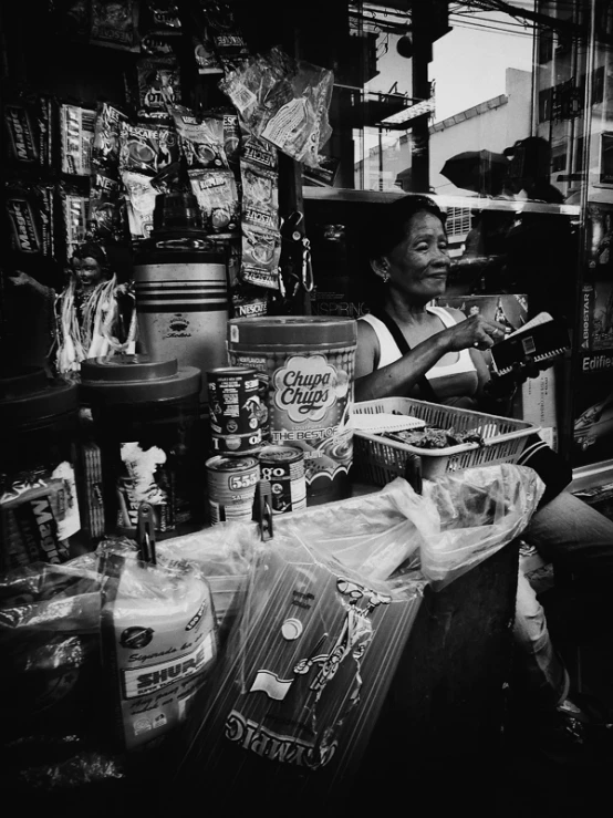 a man selling food and other items at an asian market