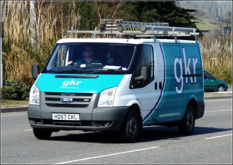 a delivery van with a person inside driving down the street