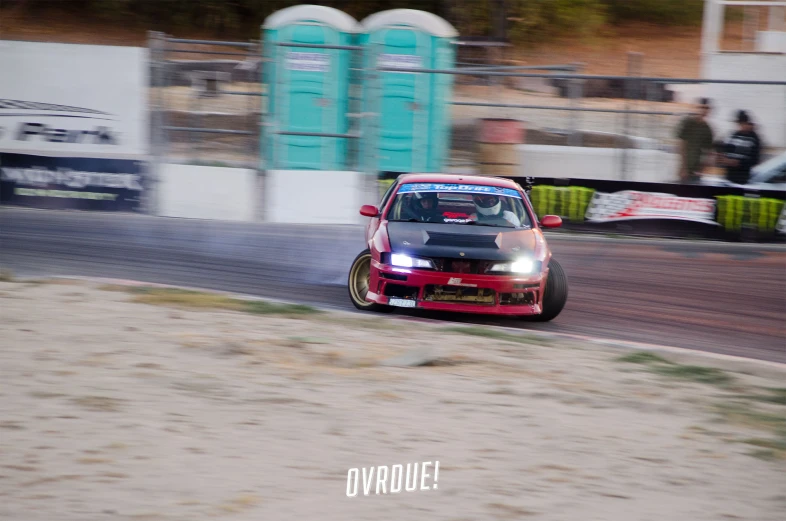 the drift car in the dirt is coming down the road