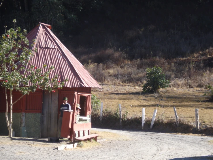 a person sitting on top of a bench at a shelter