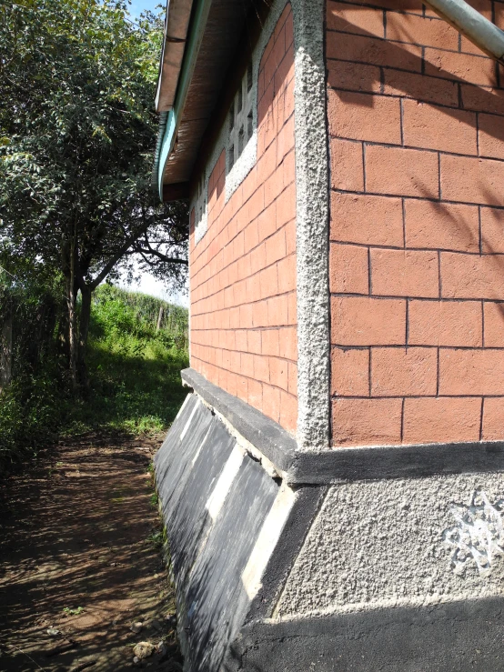 a red brick structure sitting next to a forest