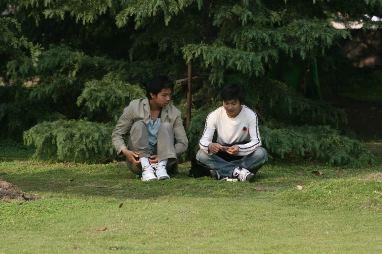 two people are sitting on the grass together