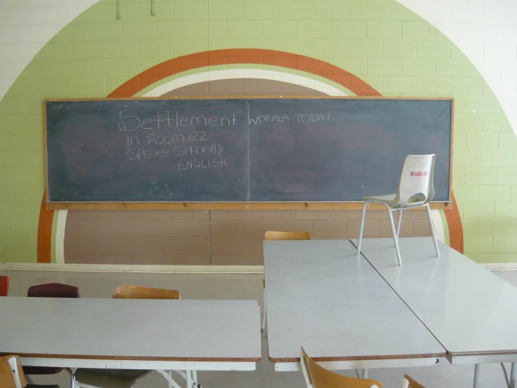 a classroom with two tables and a chalkboard