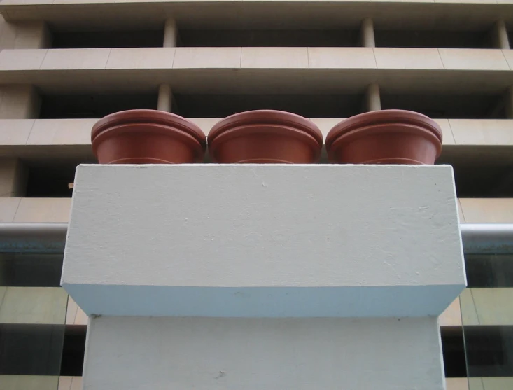 a set of clay pots on top of a white wall next to a building