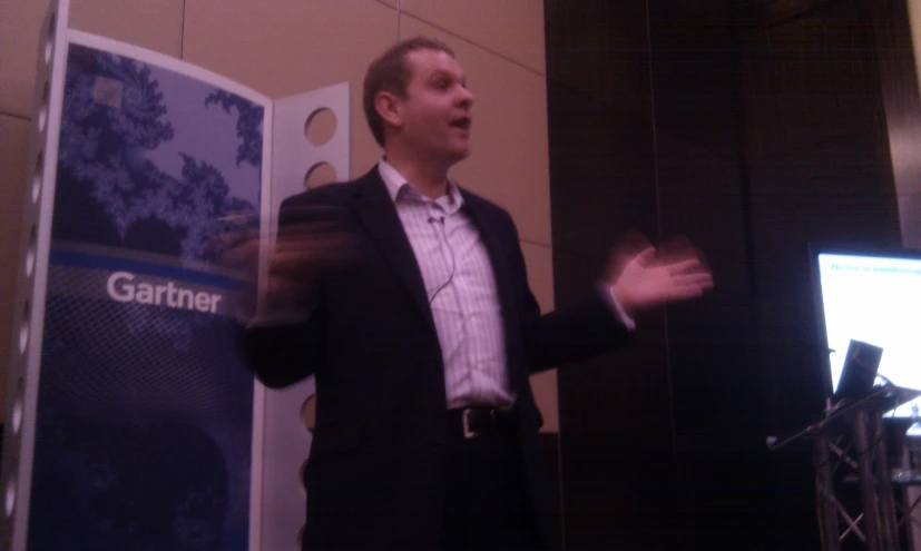 a man speaking on stage with an interactive speaker