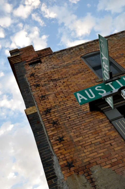 a tall brick building with a green street sign