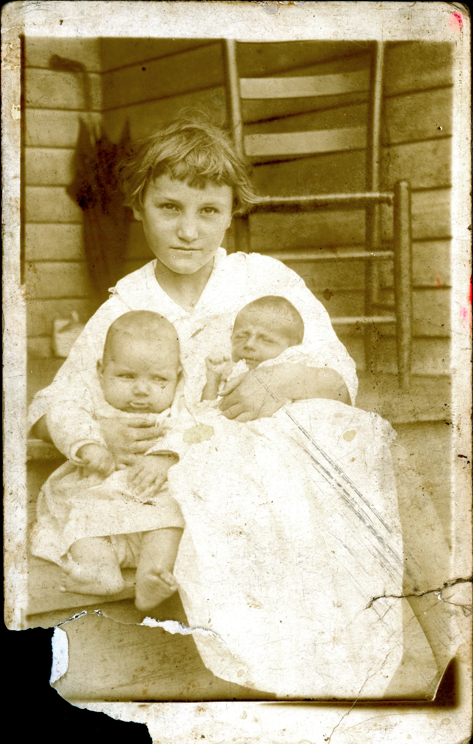 a girl holding baby dolls and a man sitting beside her