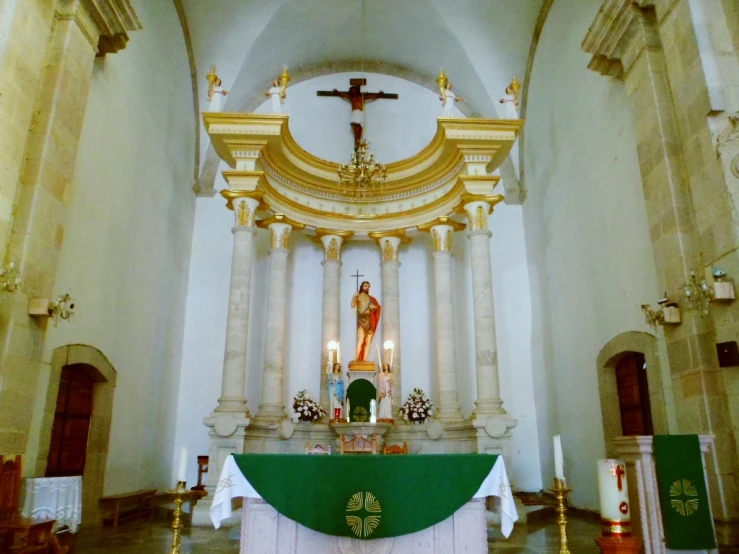 the large altar in a church is adorned with a gold cross