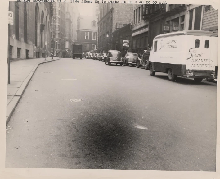 an old pograph of cars driving in the street