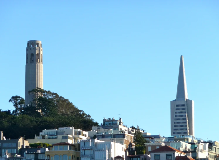 the steeple of a building rises from the hills behind