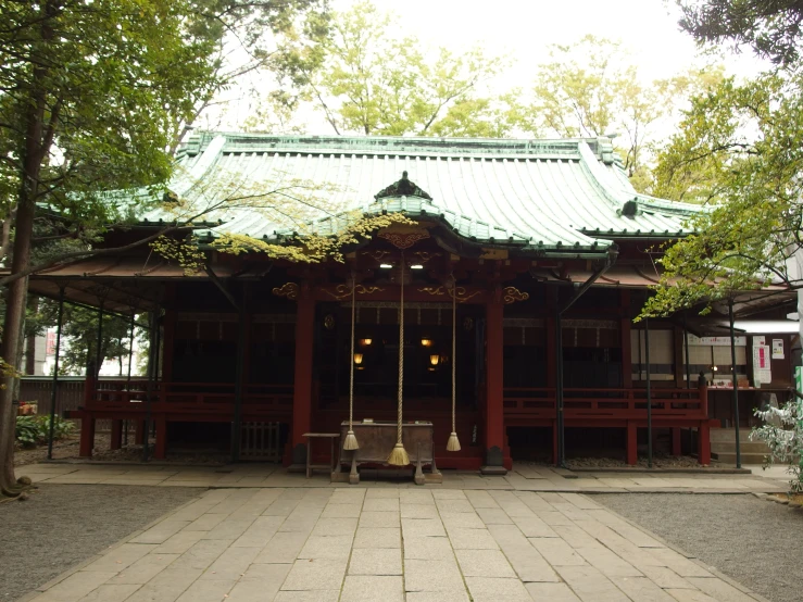 the small building is surrounded by trees and buildings