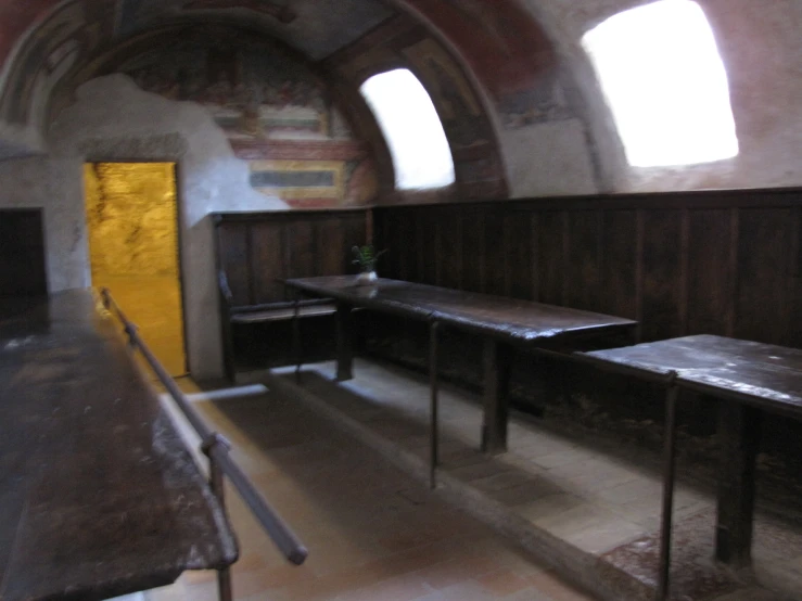 an old stone room with tables and benches