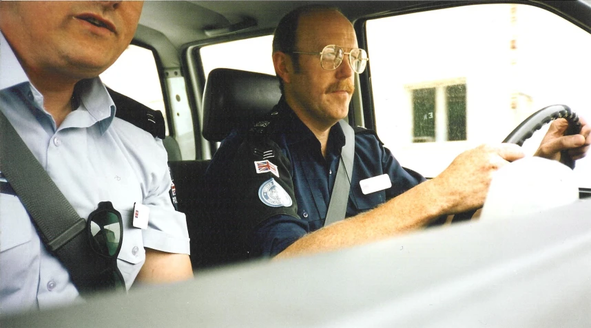 two people in a car are sitting side by side