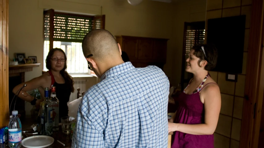 a woman and a man standing at a counter in a kitchen