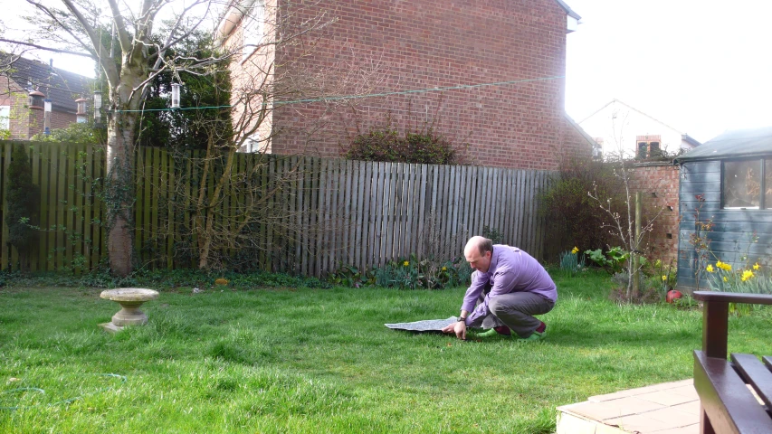 a man working on a laptop in a back yard