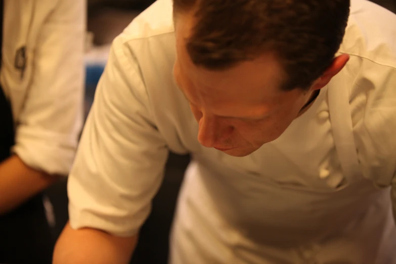 a close up of a person in an apron preparing food