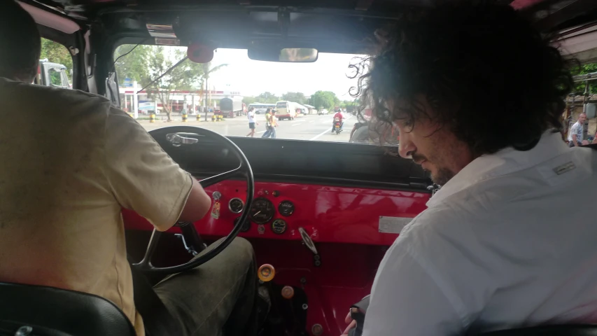 people sitting in a bus driving past another person sitting in a bus