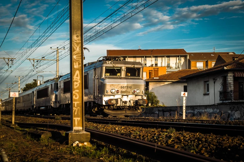 a train is riding on a track in front of an old building