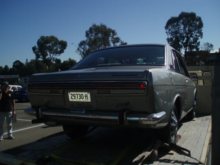 an old car is on a trailer in a parking lot