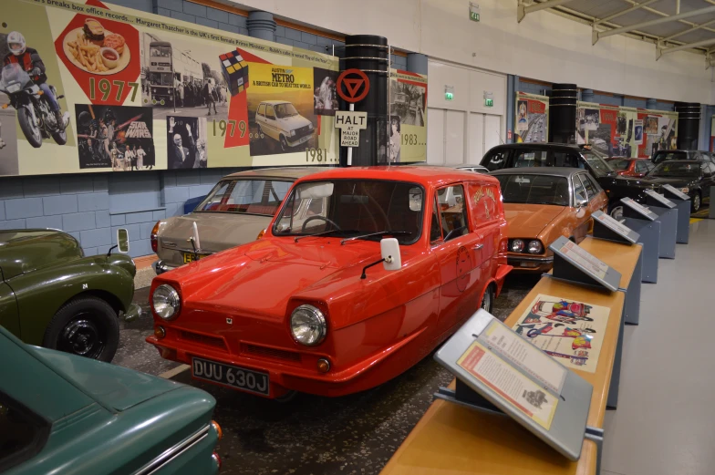 classic cars parked inside a museum with other cars behind them