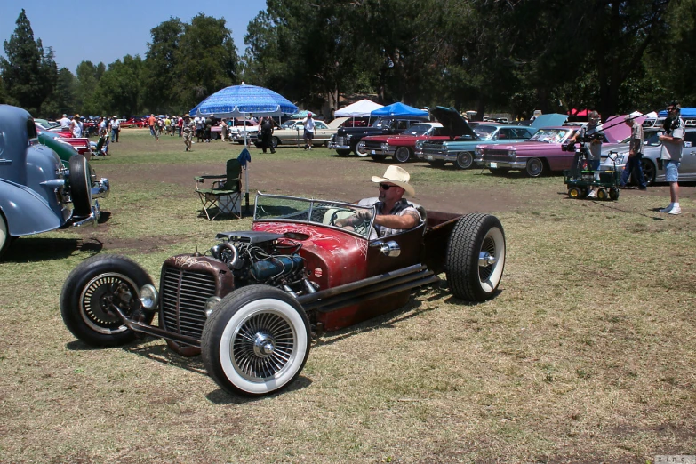 a car sitting in the grass at a classic show
